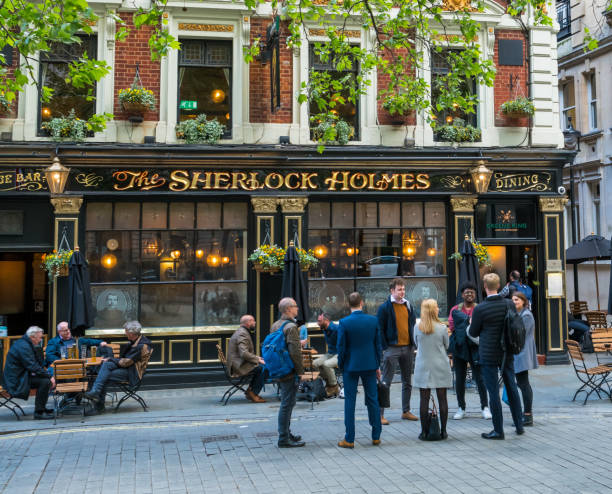 People eating and drinking outside Sherlock Holmes pub in London, UK stock photo