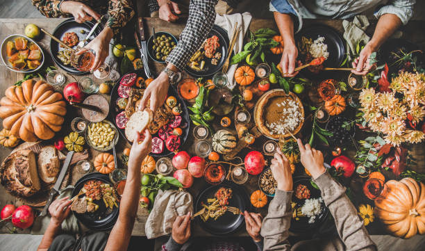 personas comiendo y bebiendo vino en la mesa de la cena de celebración de acción de gracias - thanksgiving food fotografías e imágenes de stock