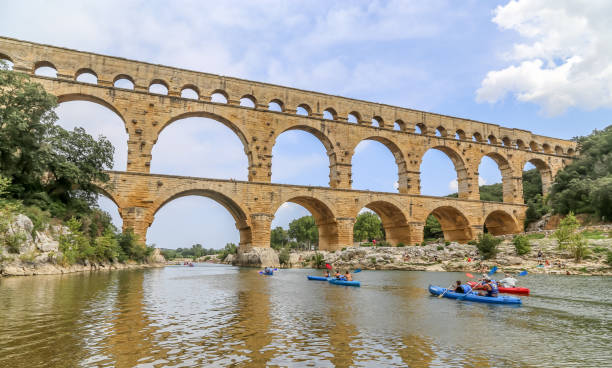 People enjoy canoeing in summer under the Pont Gard stock photo