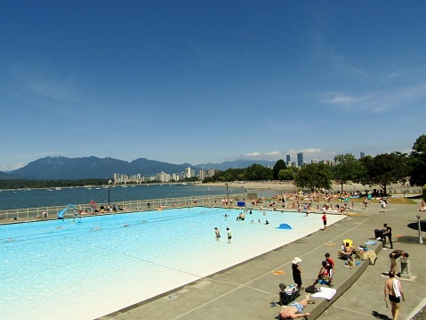 People enjoying the summer, sunbathing, swimming at the Kitsilano saltwater long outdoor pool.