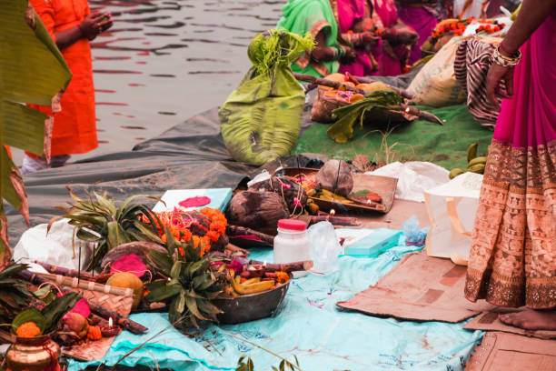 people gathered at river bed and offering fruit and vegetable to sun god people gathered at river bed and offering fruit and vegetable to sun god chhath stock pictures, royalty-free photos & images