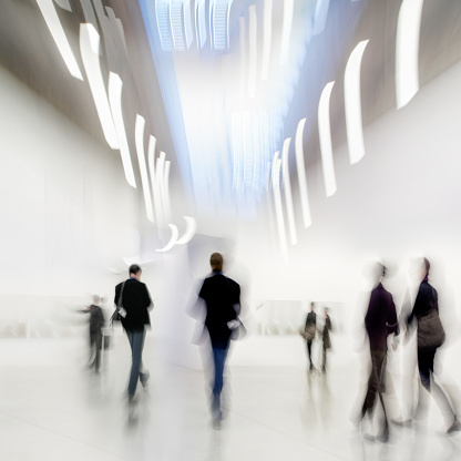 abstakt image of people in the lobby of a modern art center with a blurred background