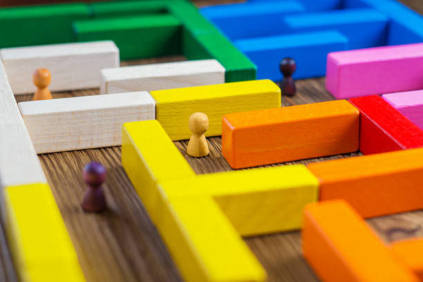 People in the maze, finding a way out. The man in the maze. The concept of a business strategy, analytics, search for solutions, the search output. Labyrinth of colorful wooden blocks, game. stock photo