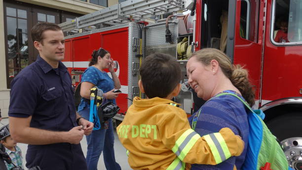 People interact with firefighters and explore trucks during fire prevention month open house stock photo