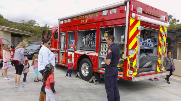 People interact with firefighters and explore trucks during fire prevention month open house stock photo