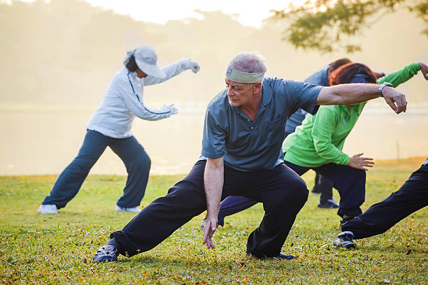 people practice Tai Chi Chuan in a park stock photo