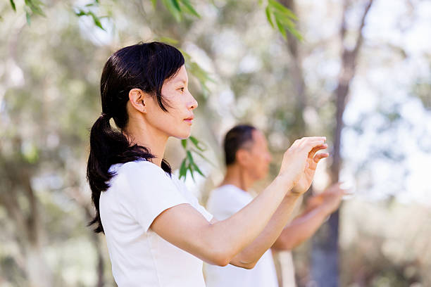 People practicing thai chi in park stock photo