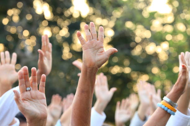 People raise their hands up for protest and uprising in demonstration event for unity and unanimous vote stock photo