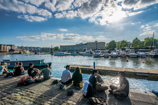 People sitting at the riverside harbour area stock photo