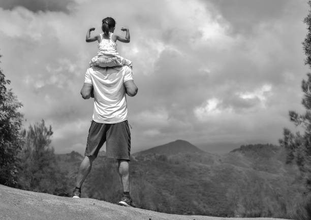 People standing on top of a mountain hike. Goals and achievement. Black and white photo of a kid making a muscle pose riding on her fathers shoulders free jpeg images stock pictures, royalty-free photos & images