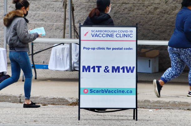 People wait in line for a Covid-19 vaccine at the pop-up vaccine clinic at L'Amoreaux Collegiate stock photo