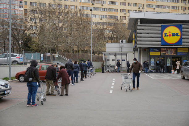 People wait in line in front of a Lidl supermarket, after a Coronavirus lockdown is announced. stock photo