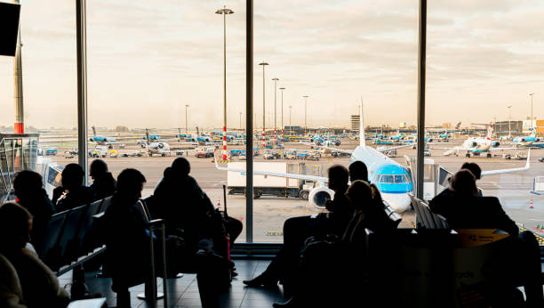mensen die wachten op vluchten op schiphol terminal b. - schiphol stockfoto's en -beelden