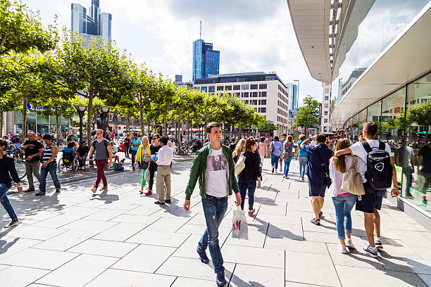people walk along the Zeil in Frankfurt Frankfurt, Germany - August 9, 2014: people walk along the Zeil in Midday  in Frankfurt, Germany. Since the 19th century it is of the most famous and busiest shopping streets in Germany. town square stock pictures, royalty-free photos & images
