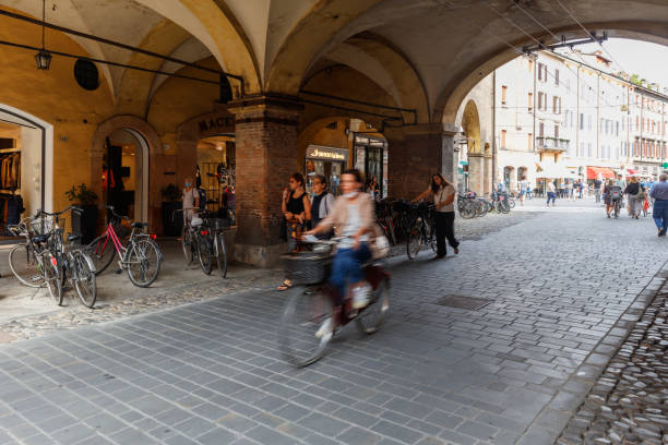 People walking and bicycles under a covered walkway (Modena, Italy) stock photo