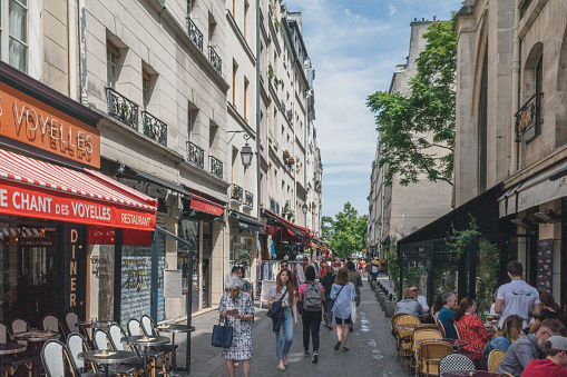Paris, France - 23 June 2019: People walking down Rue de la Verrerie with restaurants in 4th arrondissementt