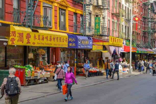 People walking next to colorful shops in Chinatown district in Manhattan New York City, USA - October 5, 2018: People walking next to colorful shops in Chinatown district in Manhattan, New York City during October 2018 chinatown stock pictures, royalty-free photos & images