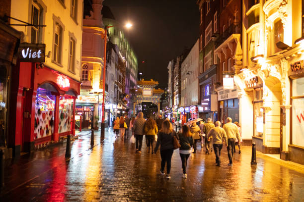 People walking on wet Gerrard Street towards Chinatown gate stock photo