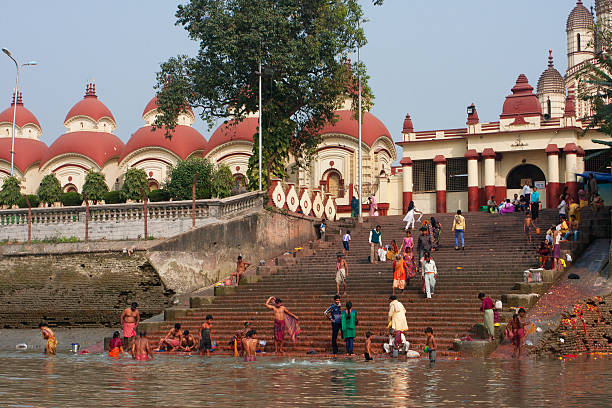 People wash in water of the ghat near Kali Temple Kolkata, India - January 17, 2013: People wash in water of the ghat near the Dakshineswar Kali Temple at the sunny day on January 17, 2013. Holy Ramakrishna came to the temple in 1855, when it was built ghat stock pictures, royalty-free photos & images