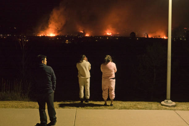 People watch night wild fires burn Superior homes in Marshall fire outside Boulder Colorado stock photo