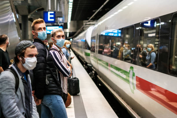 People wearing mask waiting for ICE train on platform at station( Berlin Hauptbahnhof) stock photo