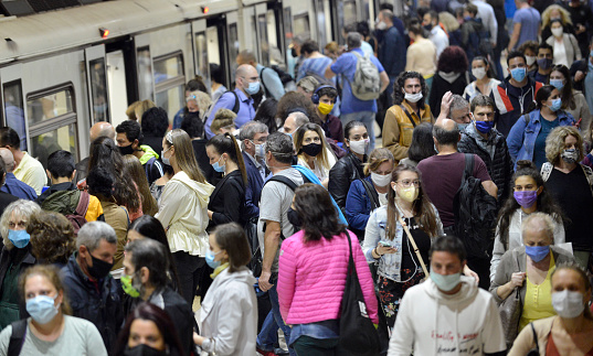 Sofia, Bulgaria - June 23 2020: Subway train passengers with protective masks crowding to get on and off subway station platform on Serdika Metro station.