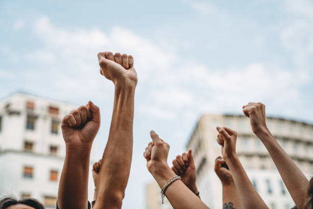 People with raised fists at a demonstration in the city stock photo