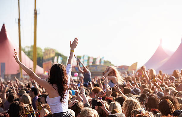 people with their arms in air at music festival - festival stockfoto's en -beelden