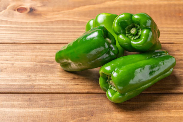 3 peppers and wood grain background stock photo