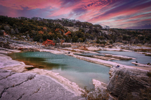 Peranales River that sometimes flows underground near LBJ Ranch in Teaas under crazy sunset sky with fall foliage stock photo