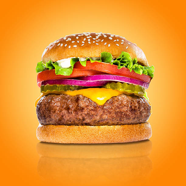 Perfect hamburger classic burger american cheeseburger isolated colorful orange background stock photo