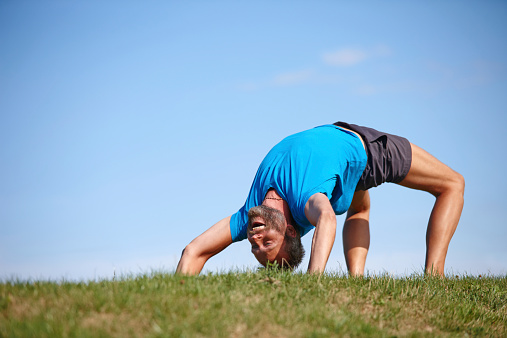 Full length shot of a handsome mature man doing yoga outdoors
