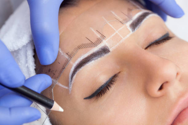 Permanent make-up for eyebrows of beautiful woman with thick brows in beauty salon. Permanent make-up for eyebrows of beautiful woman with thick brows in beauty salon. Closeup beautician doing  tattooing eyebrow. facial tattoo stock pictures, royalty-free photos & images