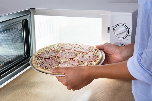 電子レンジでサラミのピザを焼く人 開いているのストックフォトや画像を多数ご用意 Istock