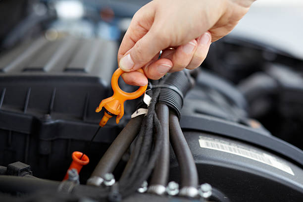 Person checks oil in a car engine stock photo