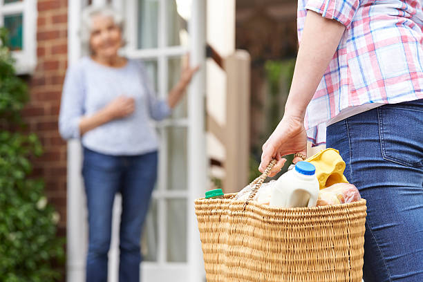 person doing shopping for elderly neighbour - boodschappen stockfoto's en -beelden