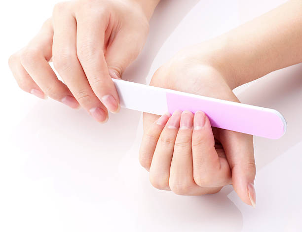 Person filing nails Person filing nails nail file stock pictures, royalty-free photos & images