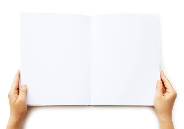 A person holding a blank book of paper  Holding a Blank White Book/ document / magazine / catalogue isolated on white.See also: spreading stock pictures, royalty-free photos & images