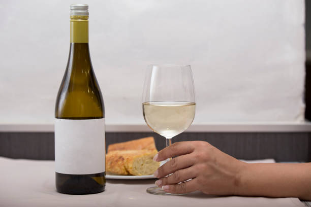 Person holding a glass of white wine stock photo
