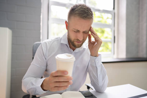 Person Holding Coffee Cup Having Headache Person Holding Coffee Cup Having Headache And Migraine caffeine stock pictures, royalty-free photos & images