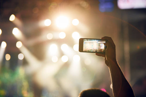 Person holding modern smartphone on a concert. stock photo