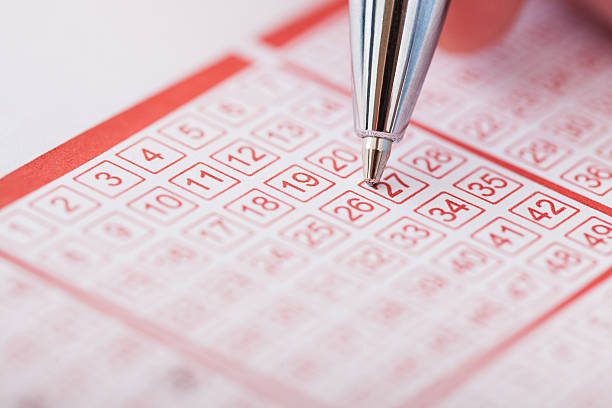 Person Holding Pen Over Lottery Ticket Close-up Of A Person Marking Number On Lottery Ticket With Pen lottery stock pictures, royalty-free photos & images