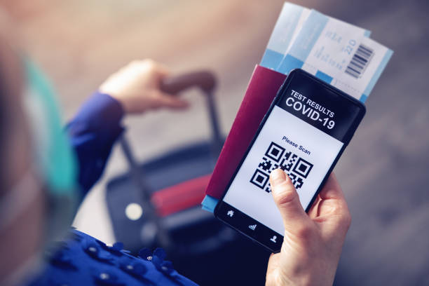 persona in aeroporto che utilizza l'app mobile al telefono per mostrare i risultati dei test covid-19 per i viaggi - travel foto e immagini stock