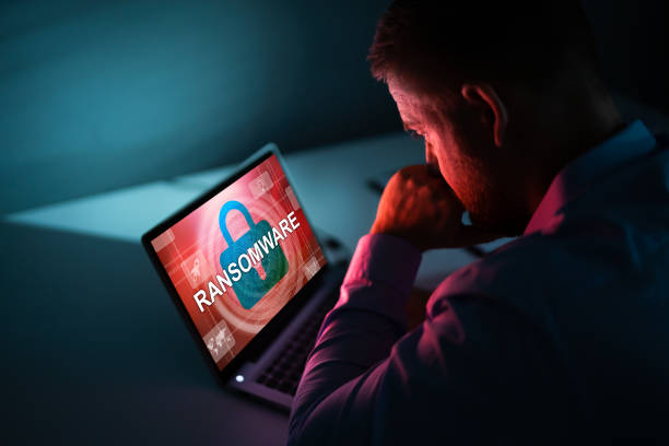 Person Looking At Laptop Screen Worried Businessman Looking At Laptop With Ransomware Word On The Screen At The Workplace ransomware stock pictures, royalty-free photos & images
