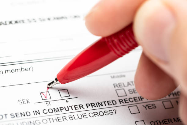 Person marking gender checkbox in a form stock photo
