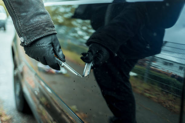 A person scratches the driver's door on a parked car with a knife A person scratches the driver's door on a parked car with a knife vandalism stock pictures, royalty-free photos & images