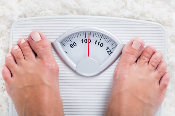 Person Standing On Weighing Scale Low Section Of Overweight Obese Person Measuring Body Weight On Weighing Scale feet unit of measurement stock pictures, royalty-free photos & images