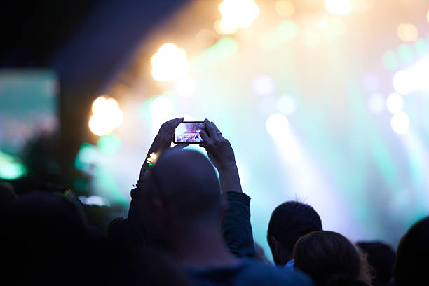 A person taking a picture of their favourite band performing