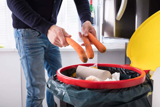 Person Throwing Carrot In Dustbin Close-up Of A Person's Hand Throwing Carrot In Dustbin rotting stock pictures, royalty-free photos & images