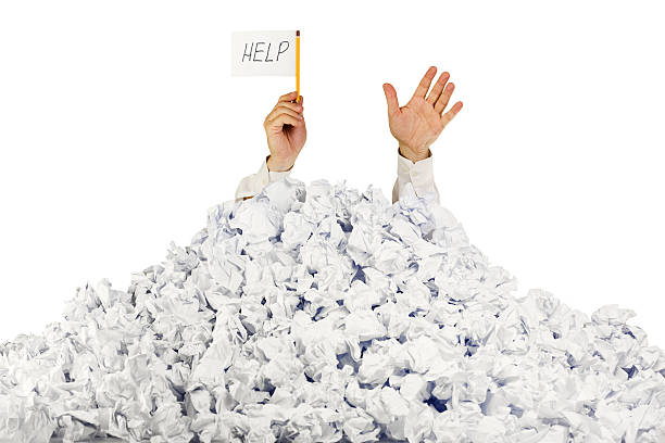 Person under crumpled pile of papers with  help sign Person under crumpled pile of papers with hand holding a help sign / isolated on white buried stock pictures, royalty-free photos & images